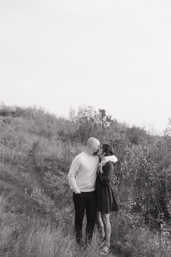 couple playing in a field during golden hour for their engagement photos