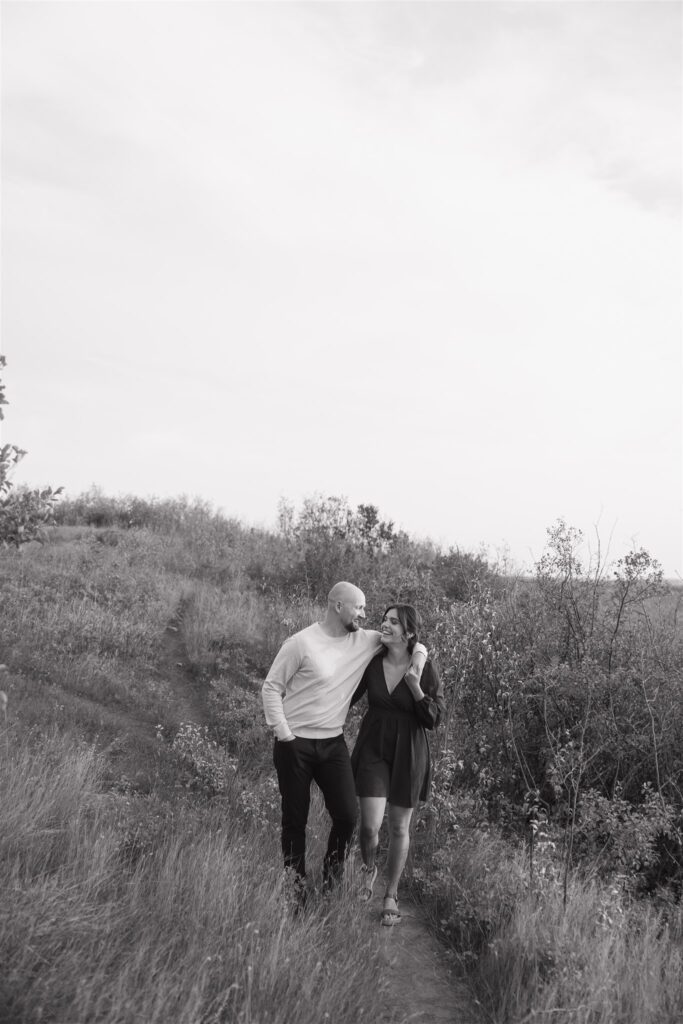 couple playing in a field during golden hour for their engagement photos