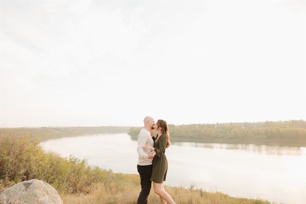 couple playing in a field during golden hour for their engagement photos