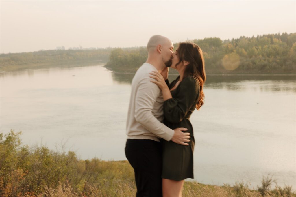 couple playing in a field during golden hour for their engagement photos