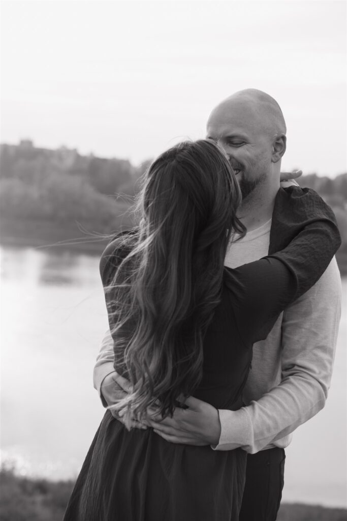 couple playing in a field during golden hour for their engagement photos