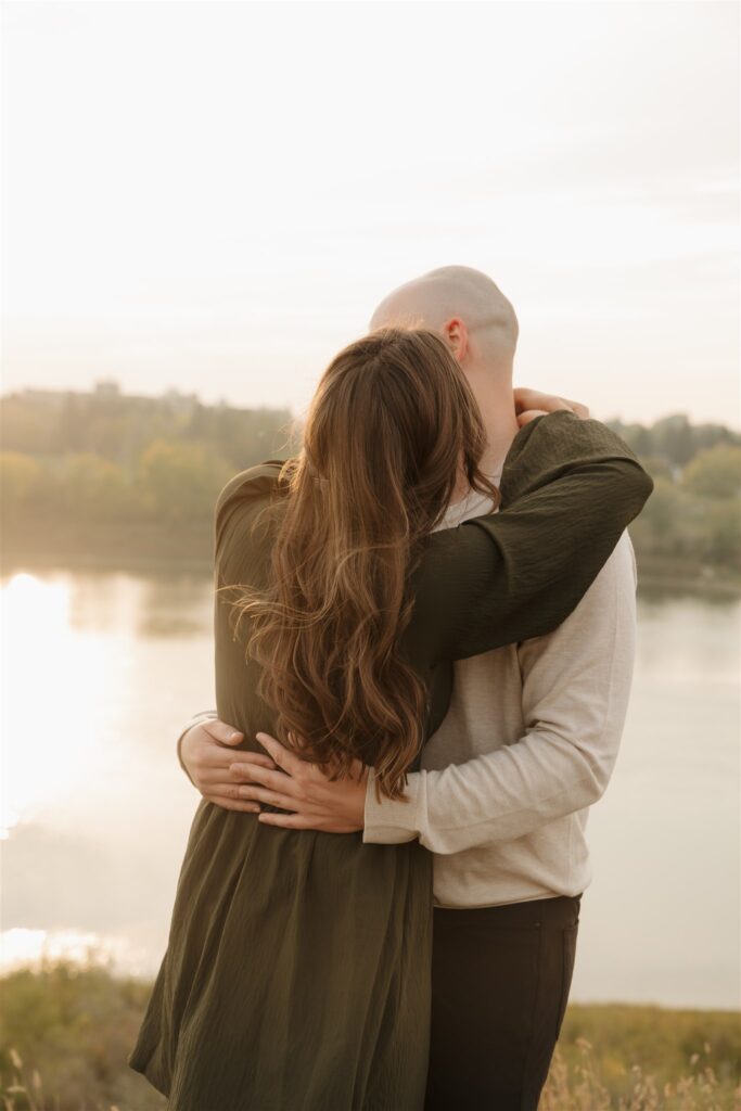 couple posing in a field for their engagement photoshoot
