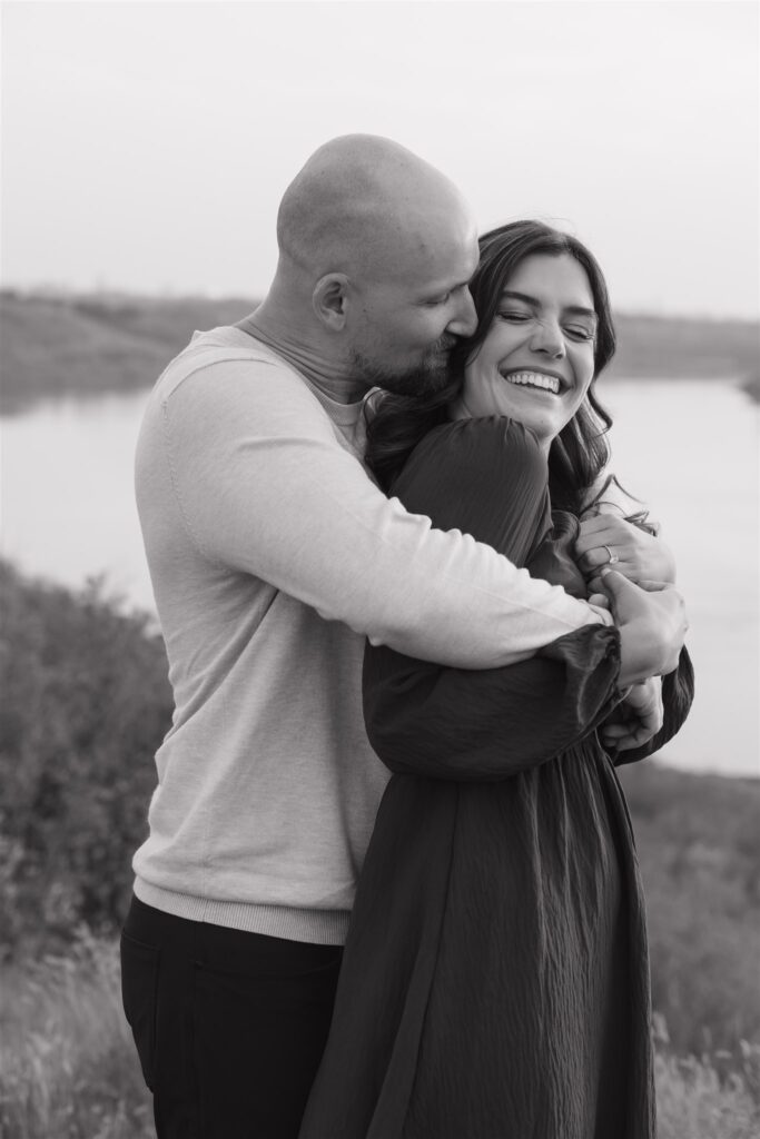 couple posing in a field for their engagement photoshoot
