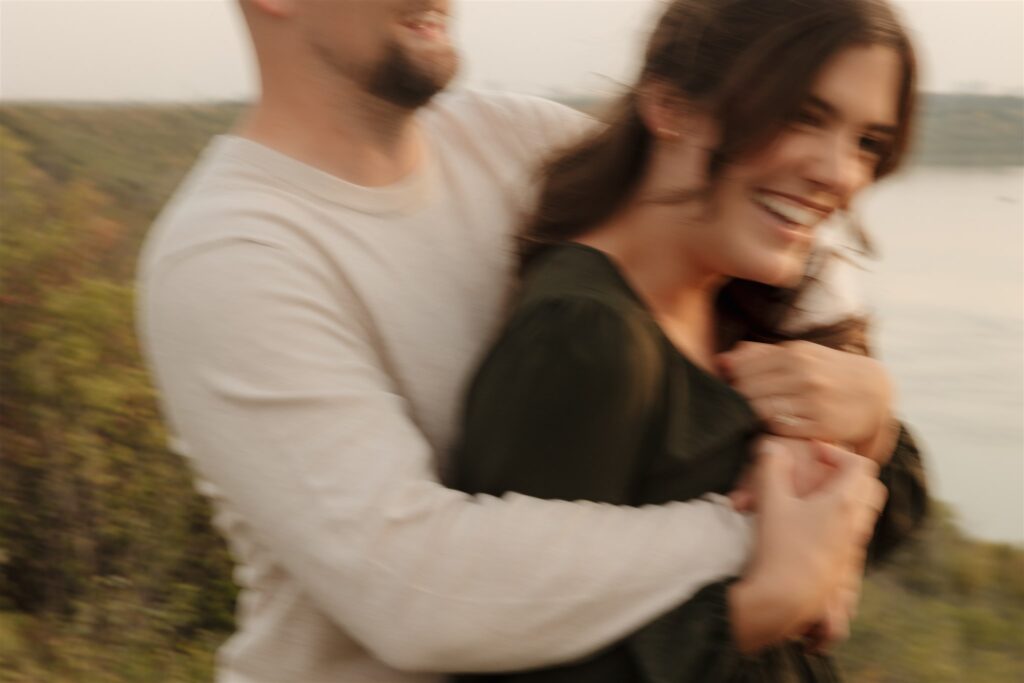 couple posing in a field for their engagement photoshoot
