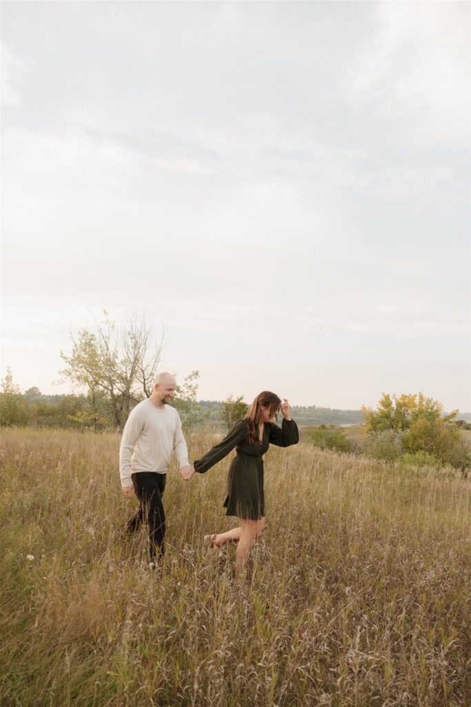 couple posing in a field for their engagement photoshoot