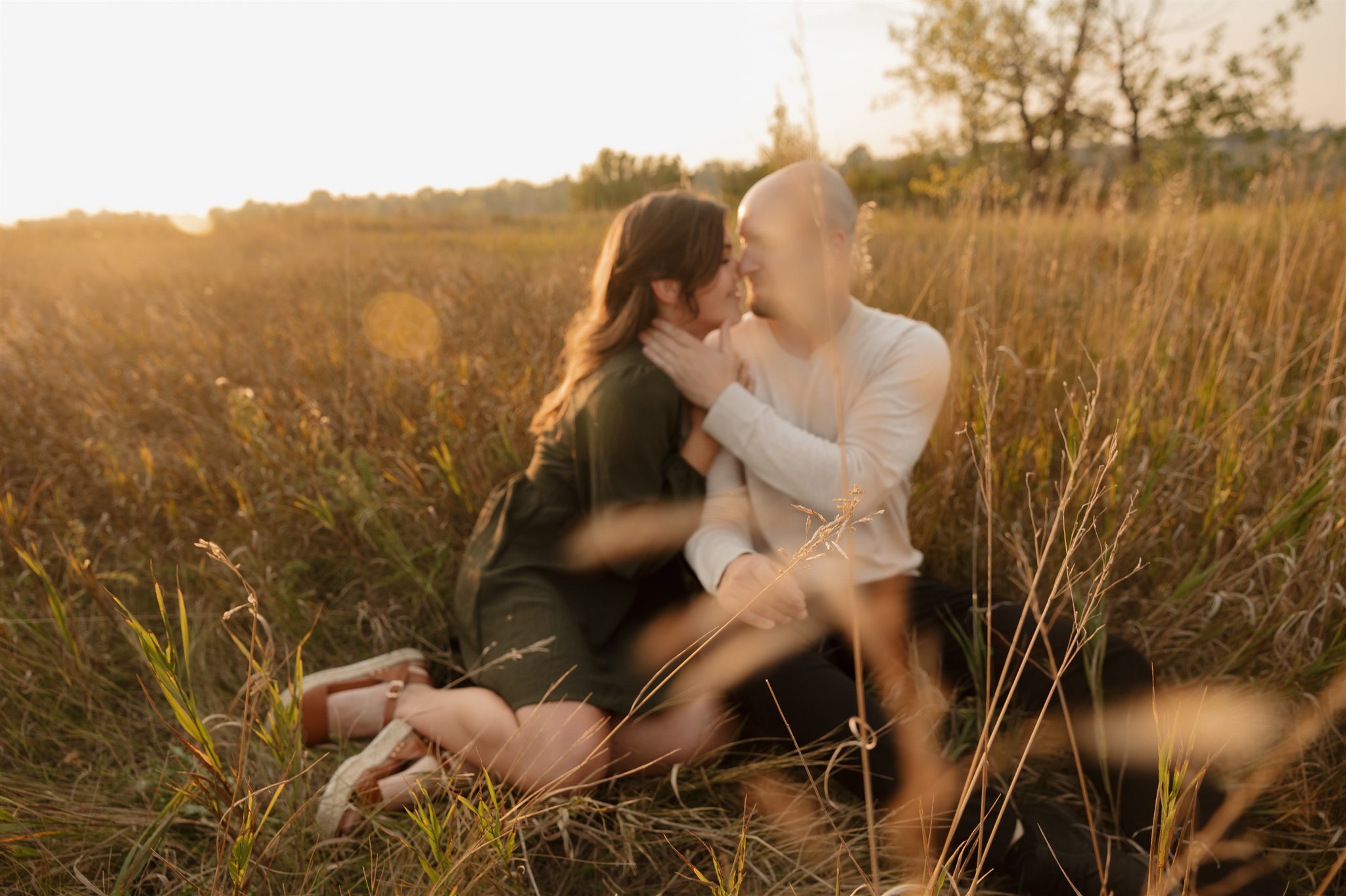 couple posing in a field for their engagement photoshoot