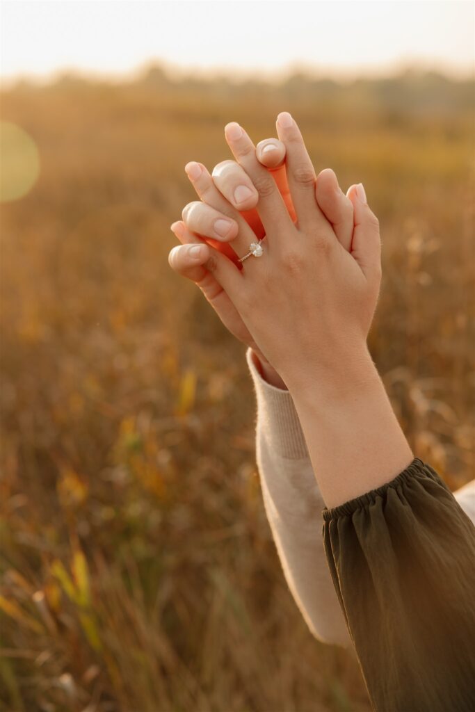 couple taking engagement photos in an open field
