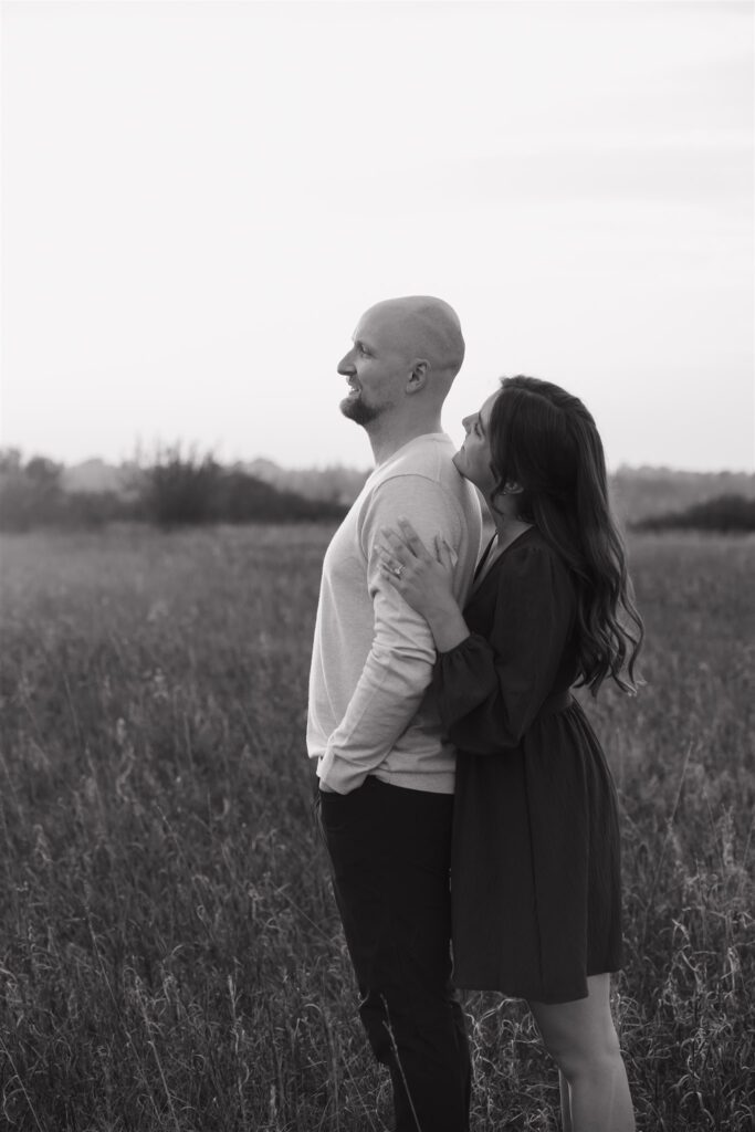 couple posing in a field for their engagement photoshoot
