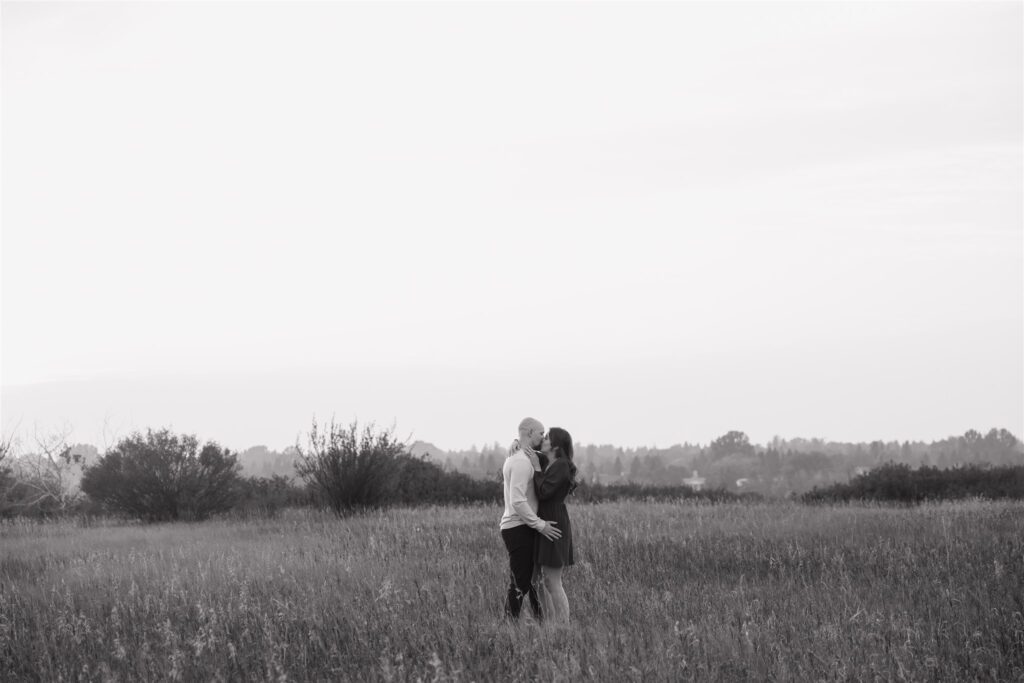 couple posing in a field for their engagement photoshoot
