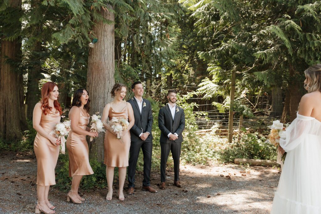 Bride and bridesmaids doing first look before forrest ceremony