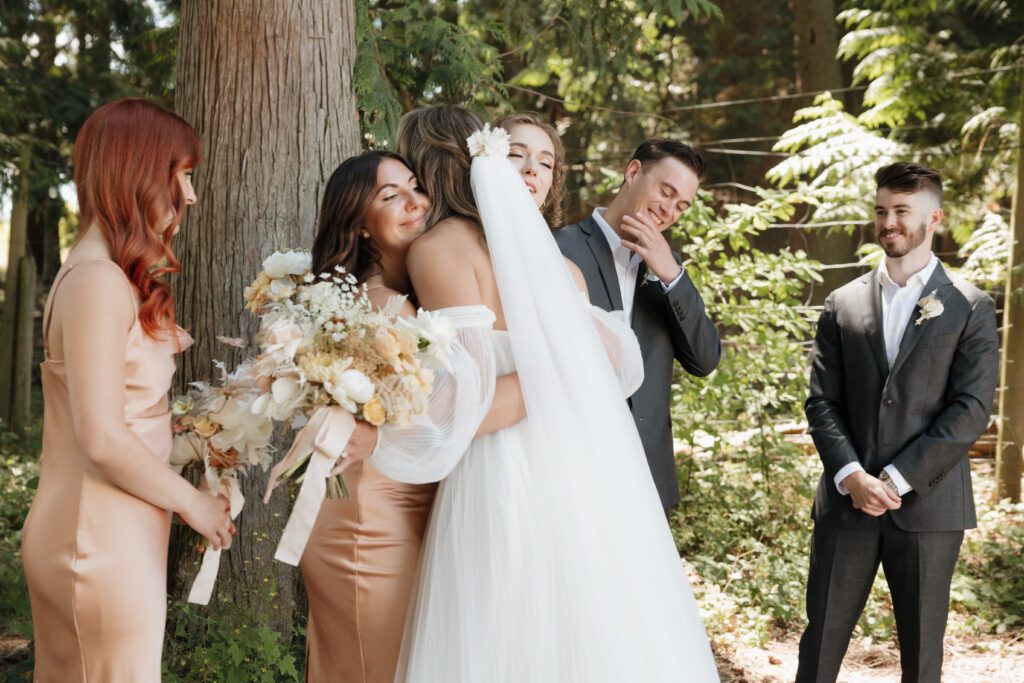 Bride and bridesmaids doing first look before forrest ceremony