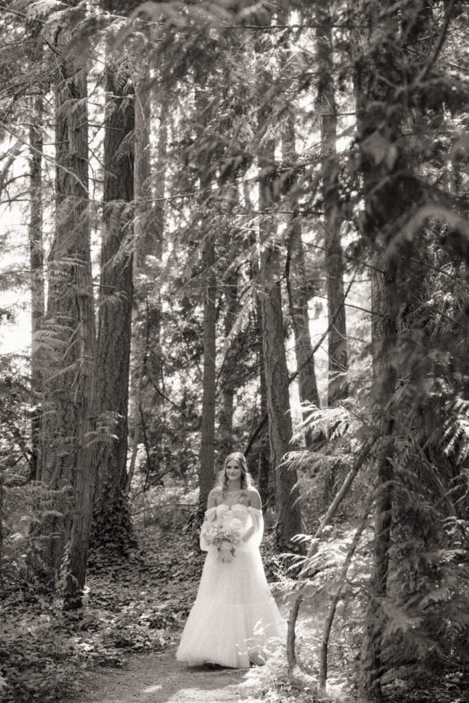 Bride walking down the aisle to her romantic forrest wedding ceremony.