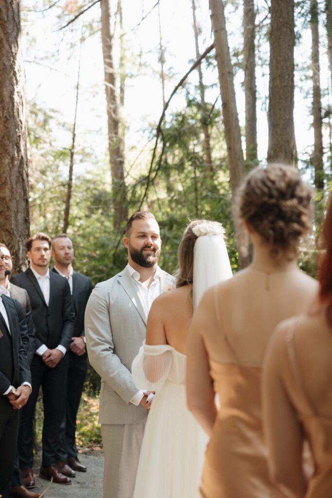 Bride and groom exchanging vows during their romantic forrest wedding ceremony.