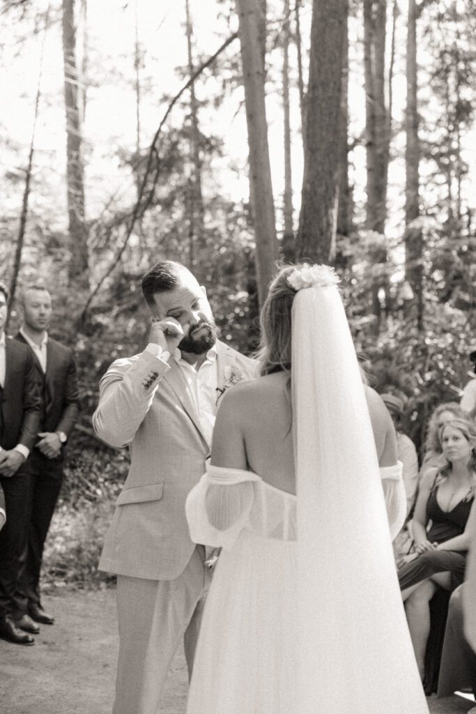 Bride and groom exchanging vows during their romantic forrest wedding ceremony.