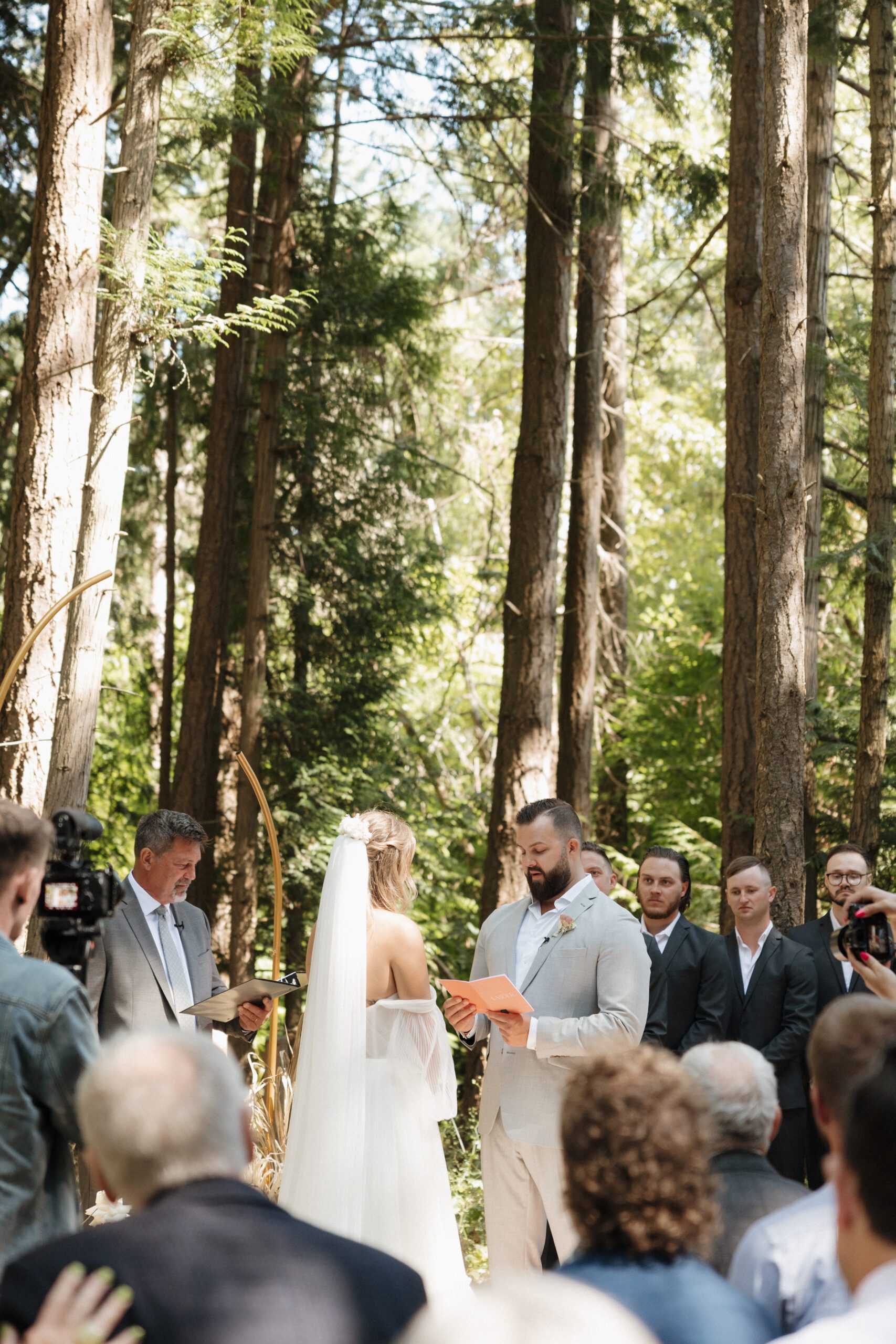 Bride and groom exchanging vows during their romantic forrest wedding ceremony.