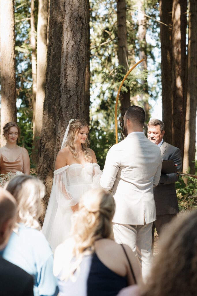 Bride and groom exchanging vows during their romantic forrest wedding ceremony.