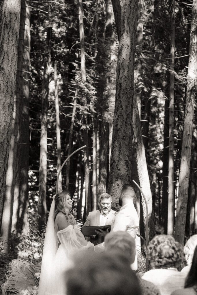 Bride and groom exchanging vows during their romantic forrest wedding ceremony.