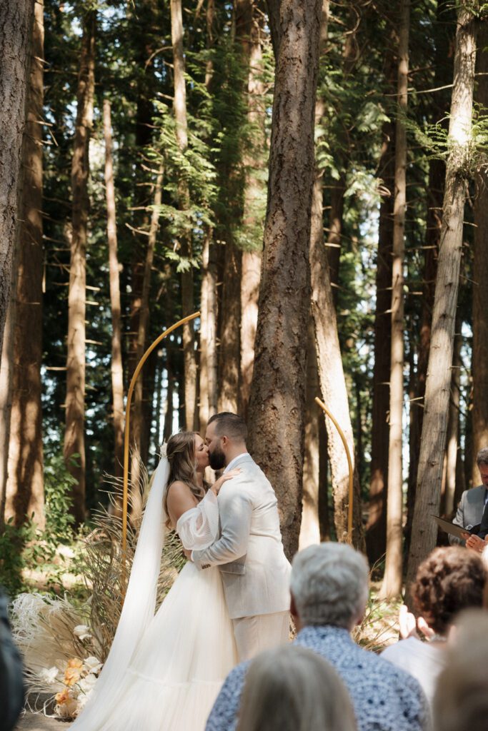 Bride and groom exchanging vows during their romantic forrest wedding ceremony.