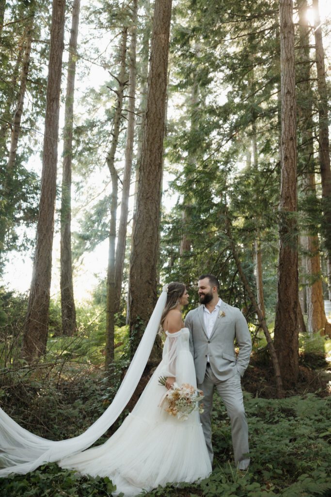 Bride and groom posing in a romantic forrest to capture elegant wedding photos.