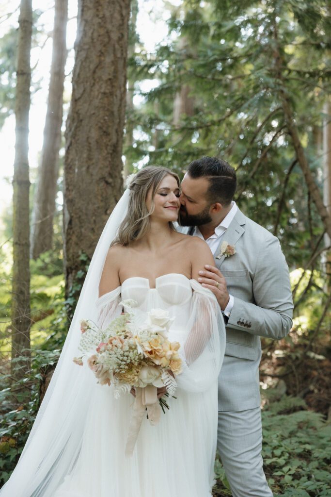 Bride and groom posing in a romantic forrest to capture elegant wedding photos.