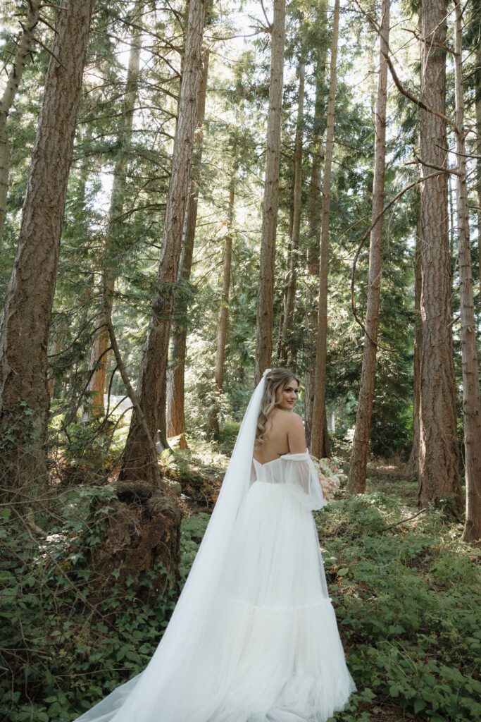 Bride and groom posing in a romantic forrest to capture elegant wedding photos.