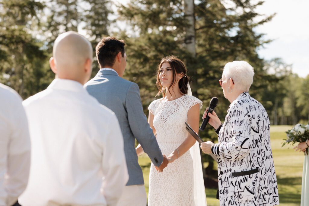 Bride and groom exchanging vows at their lakeside wedding ceremony in Candle Lake Saskatchewan