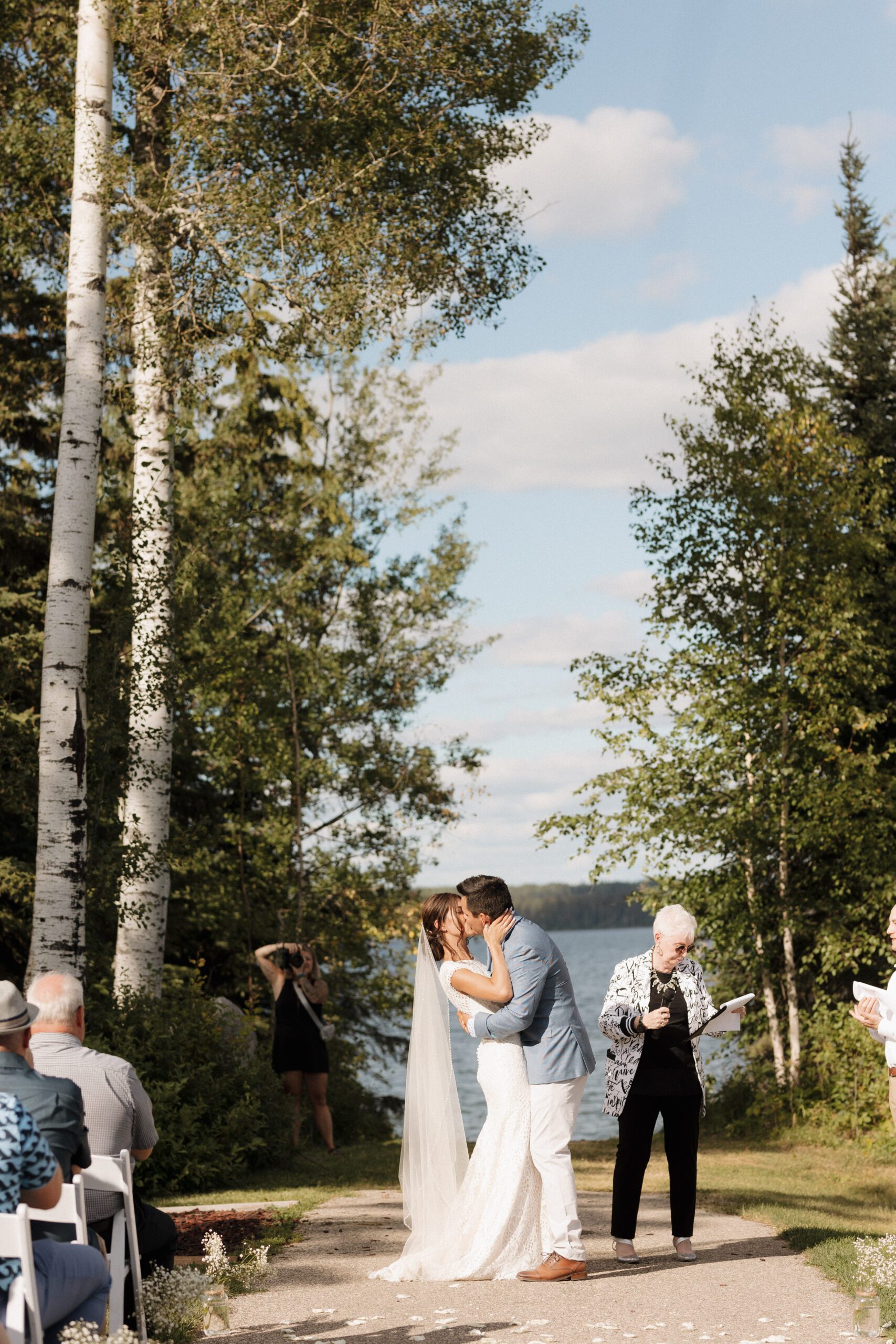 Bride and groom's first kiss at their lakeside wedding ceremony in Candle Lake Saskatchewan