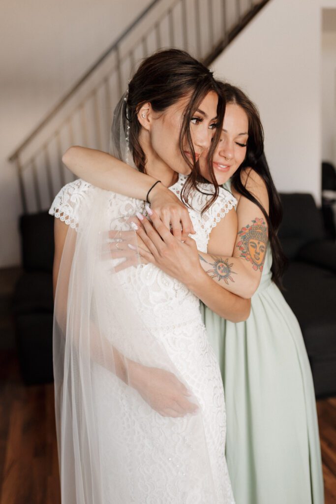 Bride's sister helping her get ready for her woodland fairytale wedding day