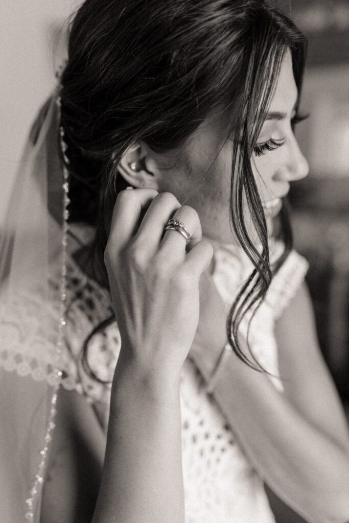 Bride's sister helping her get ready for her woodland fairytale wedding day