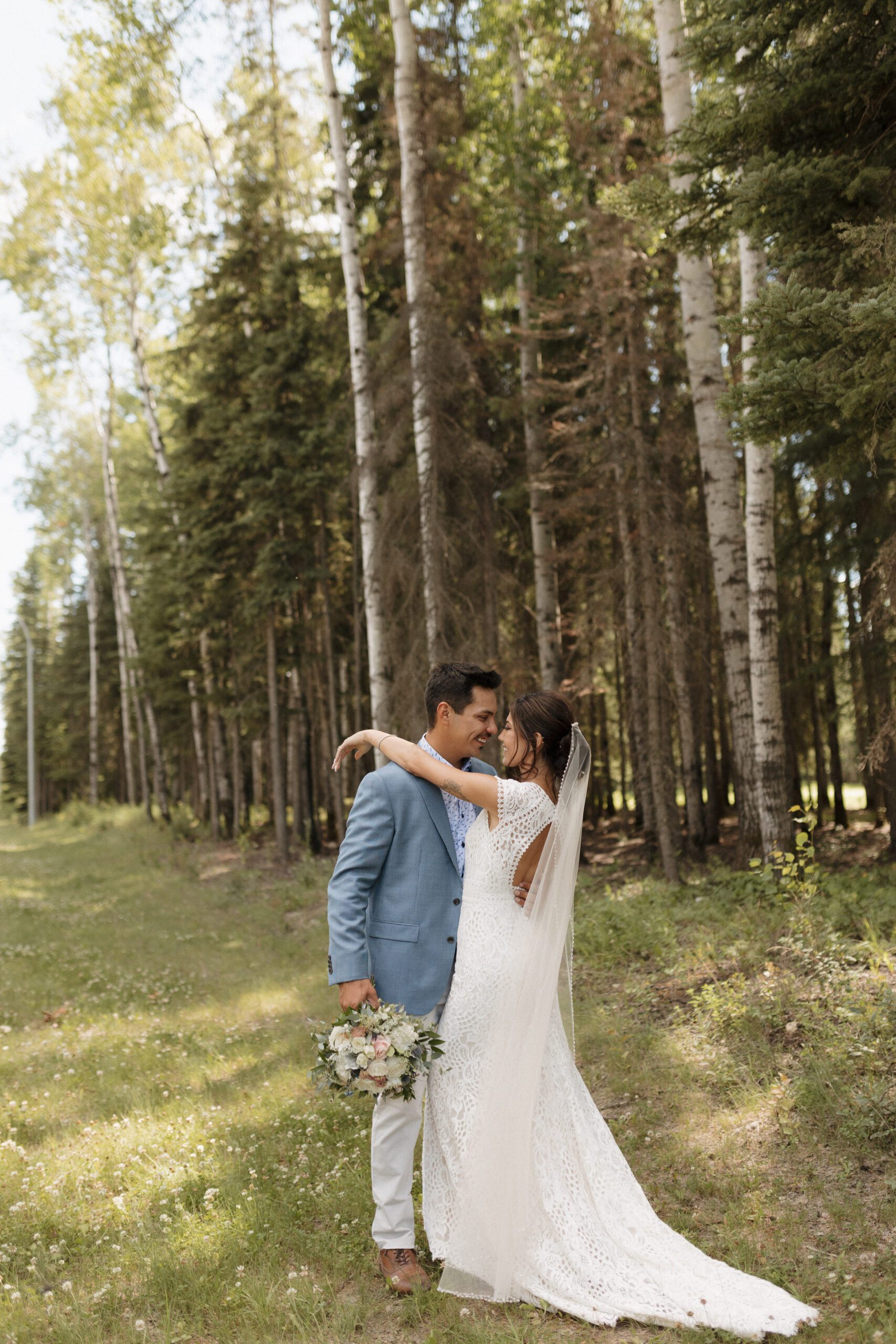 Bride and groom taking bridals in the forrest in Candle Lake Saskatchewan