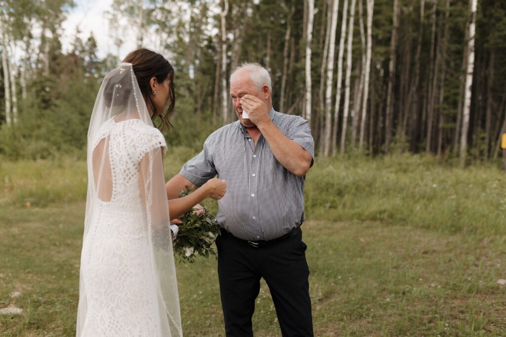 Bride and her father during their first look before their Candle Lake Wedding