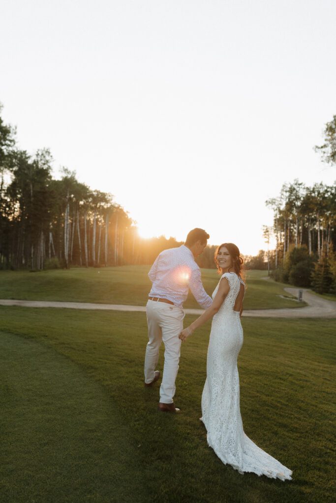 Bride and groom taking golden hour photos on the Candle Lake Golf course 