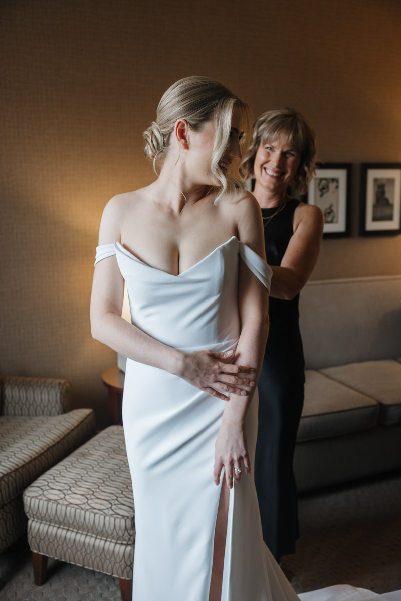 Bride getting ready at Sheraton Cavalier Saskatoon Hotel, wearing a timeless Alyssa Kristin wedding dress, with natural glam by Free Bird Hair Design