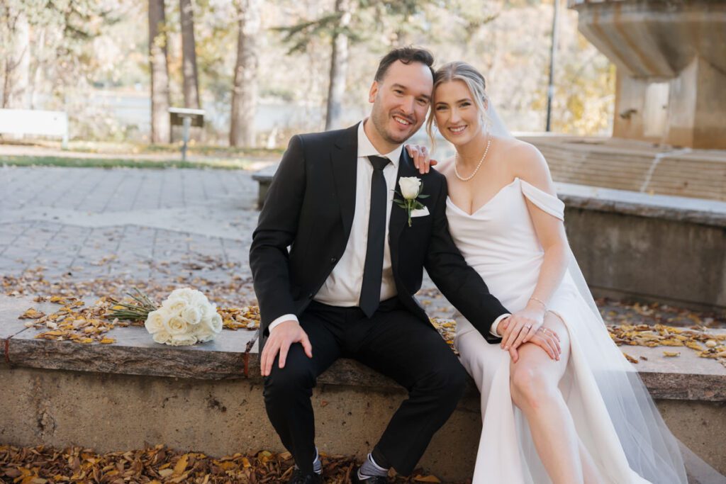 Bride and groom sharing a quiet laugh during golden hour portraits, embodying timeless love on their elegant wedding day.