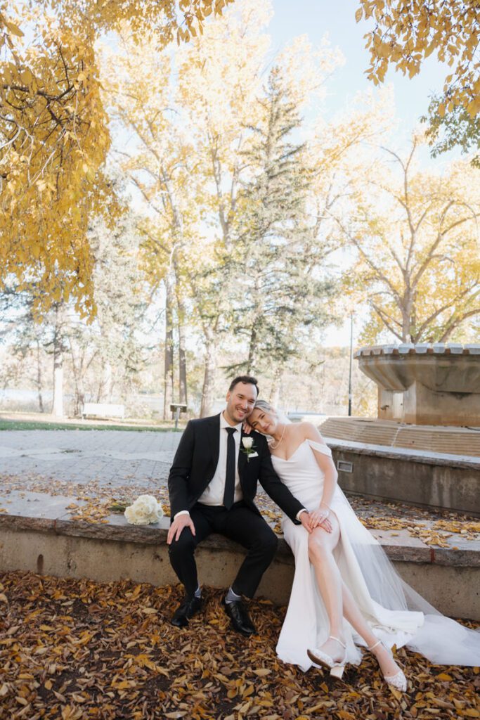 Bride and groom sharing a quiet laugh during golden hour portraits, embodying timeless love on their elegant wedding day.