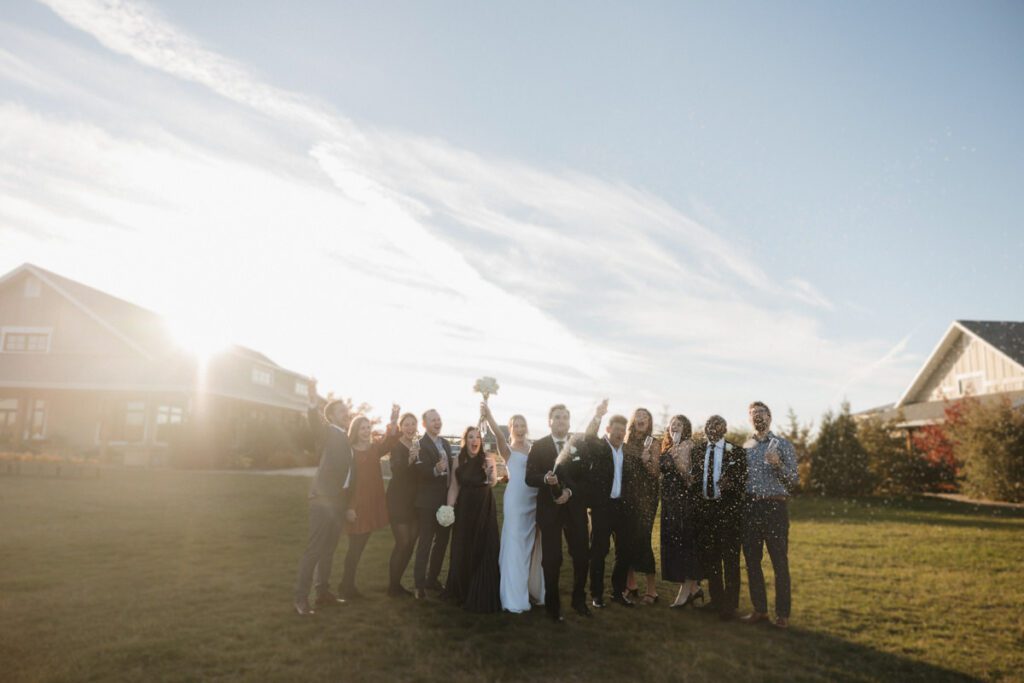 Guests raising their glasses during emotional toasts at a refined, joyful wedding reception in Saskatoon.