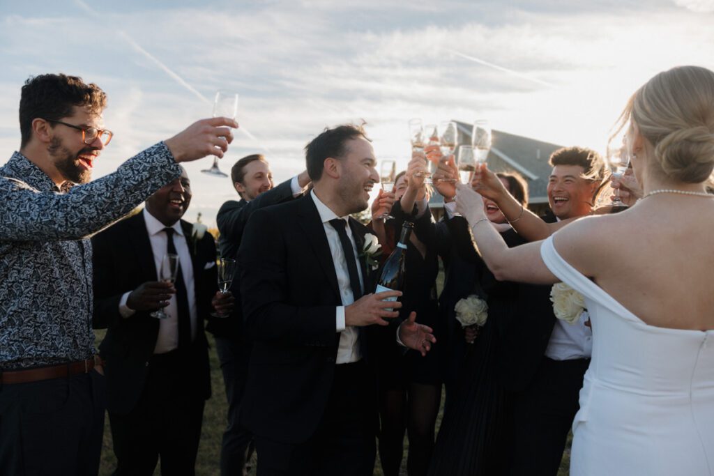 Guests raising their glasses during emotional toasts at a refined, joyful wedding reception in Saskatoon.