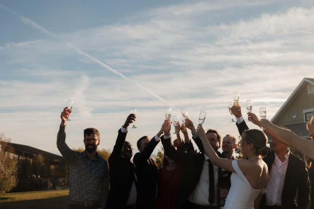 Guests raising their glasses during emotional toasts at a refined, joyful wedding reception in Saskatoon.