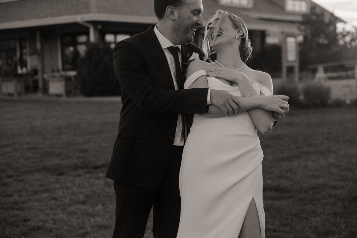 Bride and groom sharing a quiet laugh during golden hour portraits, embodying timeless love on their elegant wedding day
