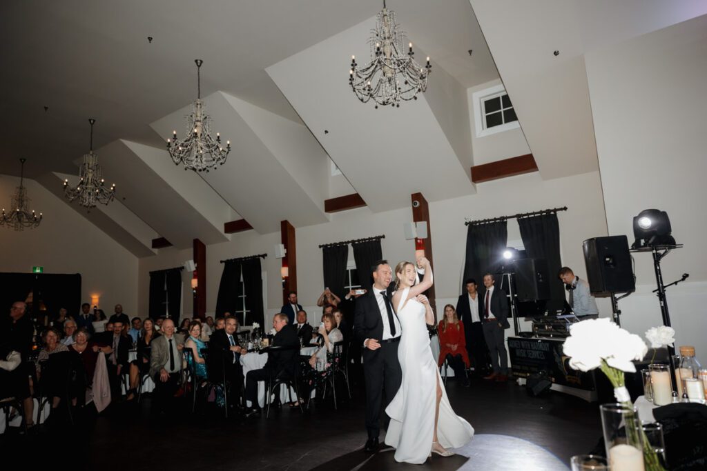 Bride and groom sharing their first dance under twinkle lights during their timeless, elegant wedding reception in Saskatoon.