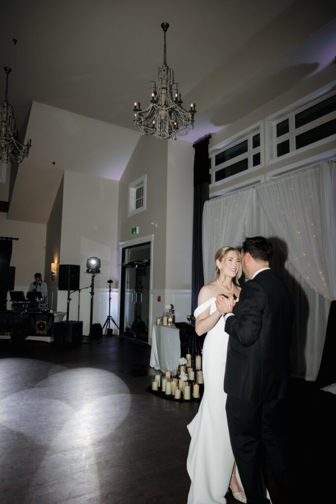 Bride and groom sharing their first dance under twinkle lights during their timeless, elegant wedding reception in Saskatoon.