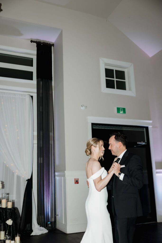 Groom twirling the bride during an upbeat moment on the dance floor at their elegant fall wedding celebration.