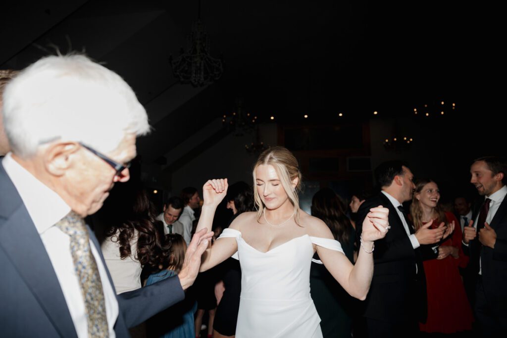 Groom twirling the bride during an upbeat moment on the dance floor at their elegant fall wedding celebration.