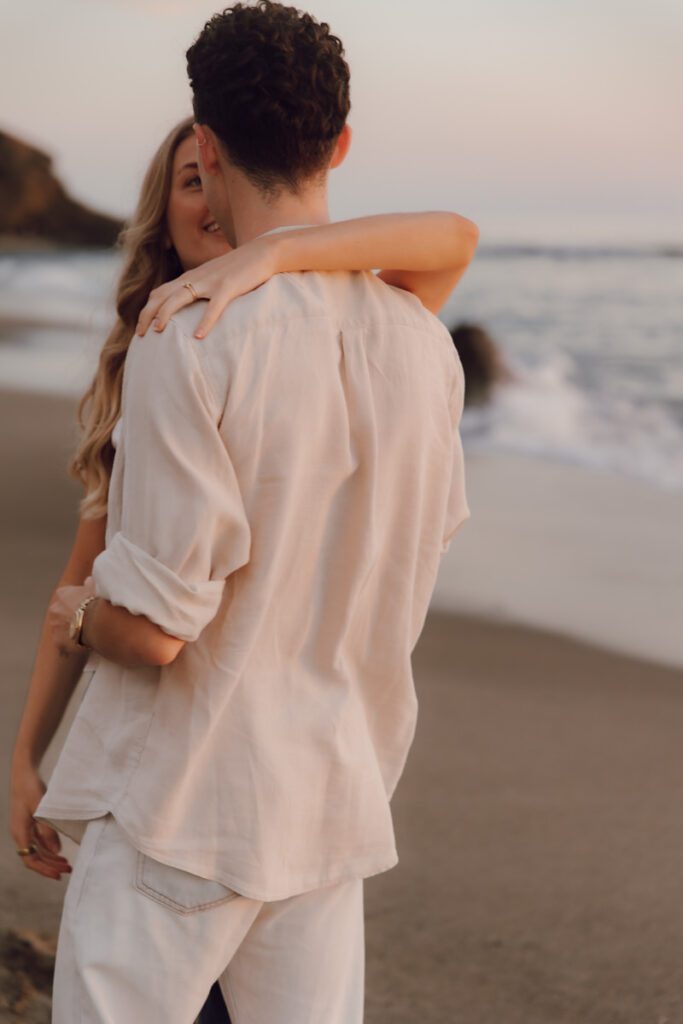 Lauren and Ben dancing on the shoreline as the sky turns golden