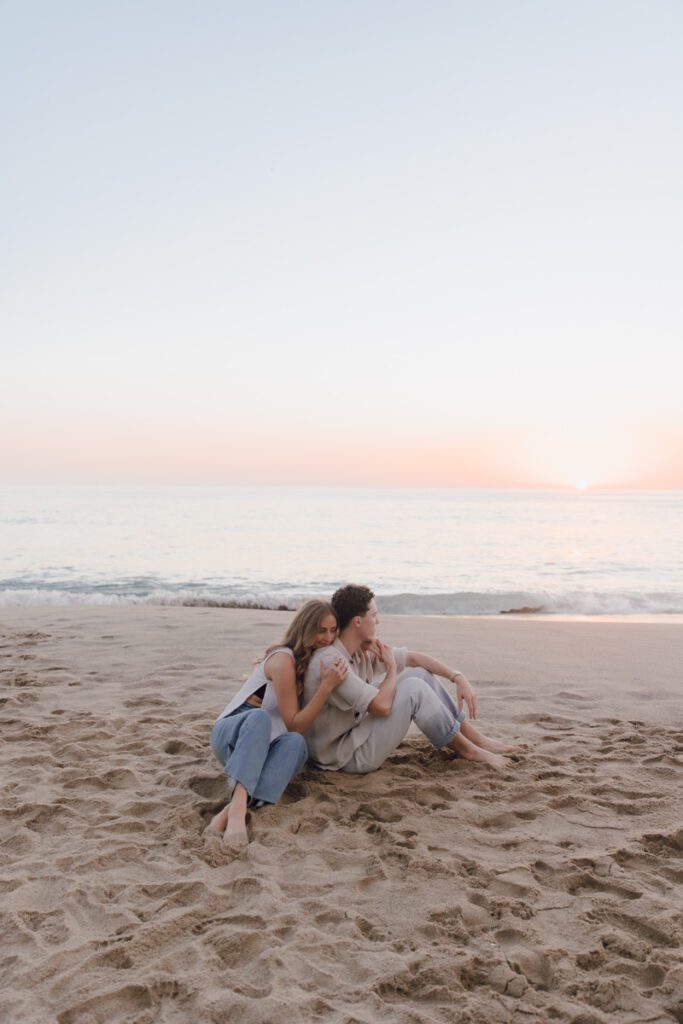 Intimate moment between the couple, silhouetted against the setting sun