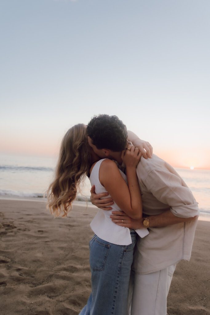 Lauren and Ben dancing on the shoreline as the sky turns golden