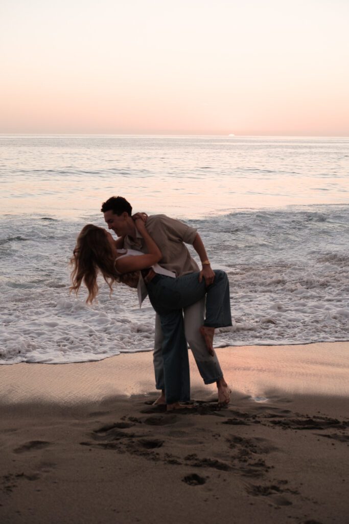 Lauren and Ben dancing on the shoreline as the sky turns golden