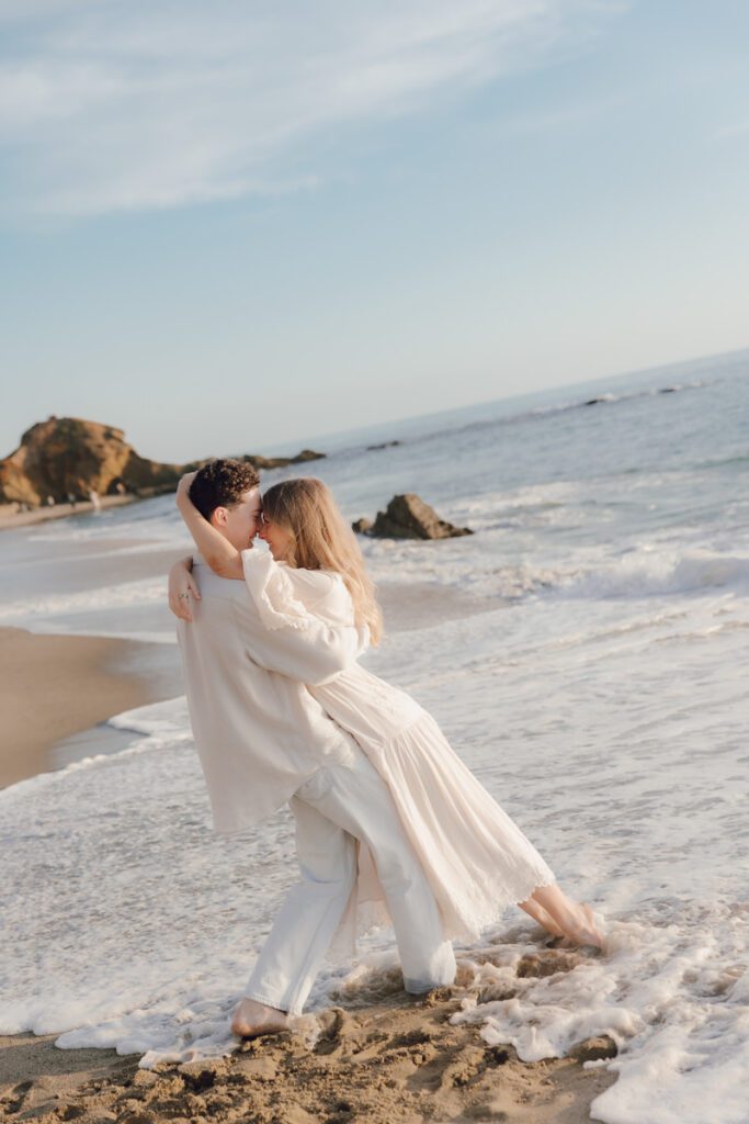 Lauren and Ben dancing on the shoreline as the sky turns golden