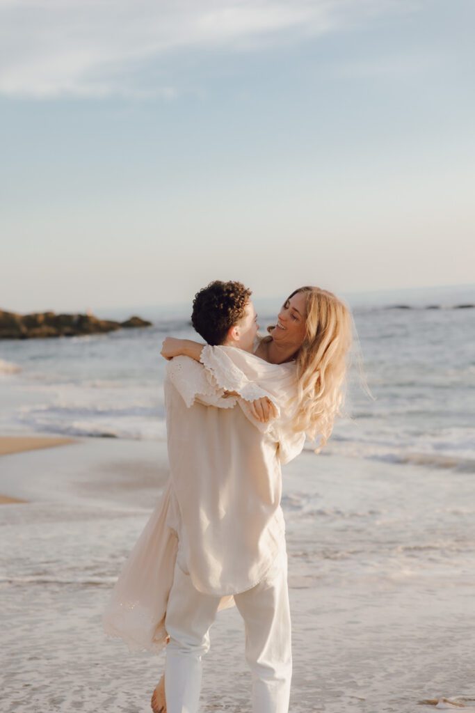 Lauren and Ben dancing on the shoreline as the sky turns golden