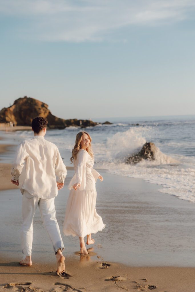 Lauren and Ben dancing on the shoreline as the sky turns golden